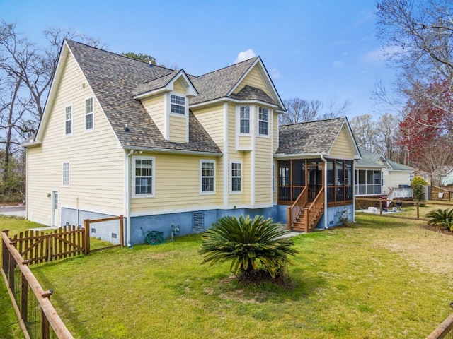 rear view of house with a fenced backyard, a shingled roof, a yard, and a sunroom