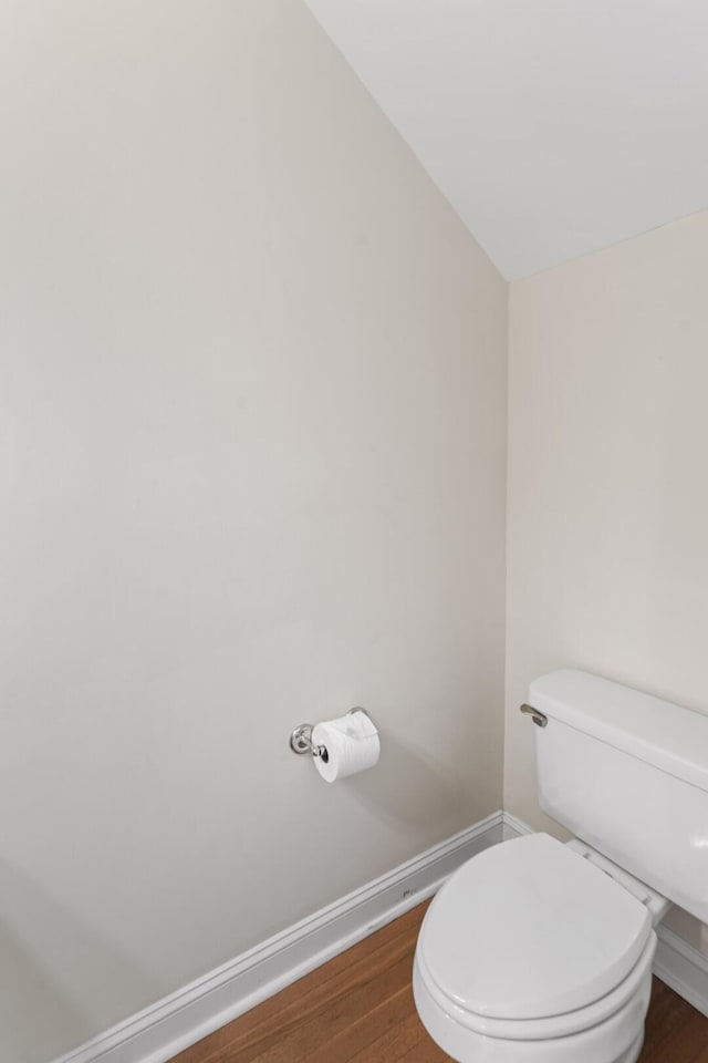 bathroom featuring toilet, wood finished floors, and baseboards