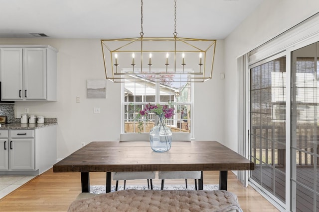 dining room with light wood finished floors and visible vents