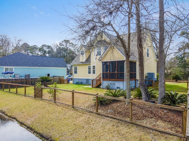 view of front facade with fence, a front yard, and a sunroom