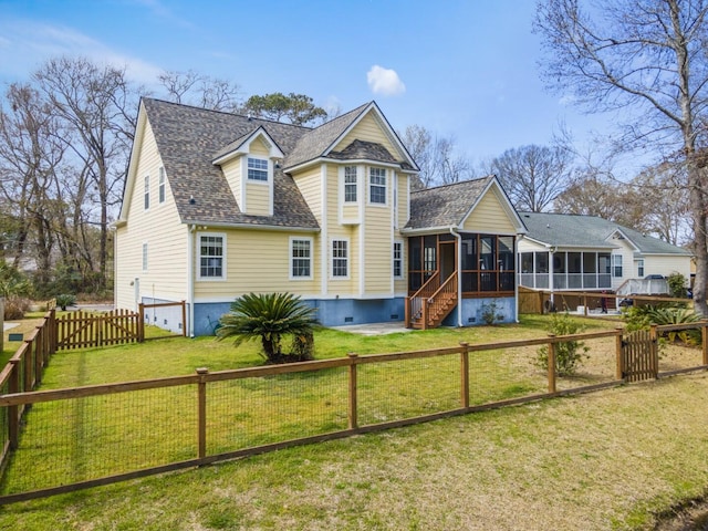 view of front of house featuring a shingled roof, a fenced backyard, a front yard, and a sunroom