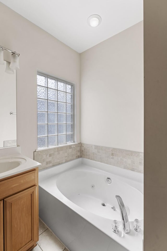 bathroom with tile patterned floors, vanity, and a whirlpool tub