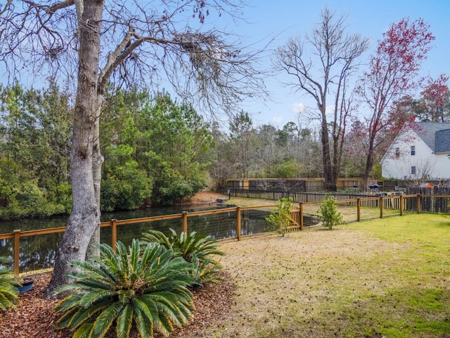 view of yard with a water view and fence