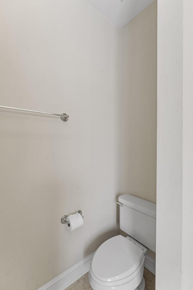 bathroom featuring toilet and baseboards