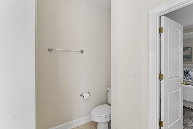 ensuite bathroom featuring tile patterned floors, toilet, baseboards, and ensuite bathroom