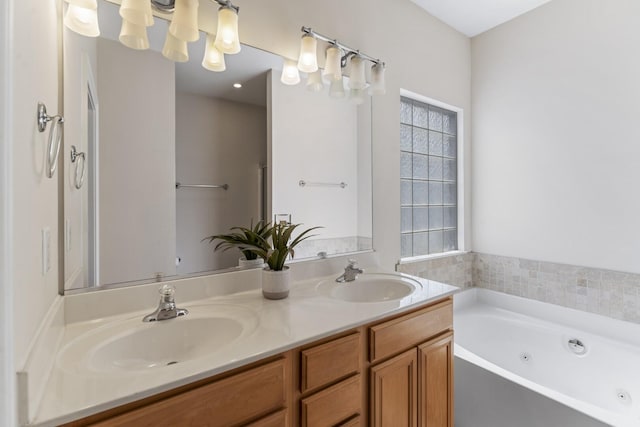 bathroom featuring a sink, a jetted tub, and double vanity