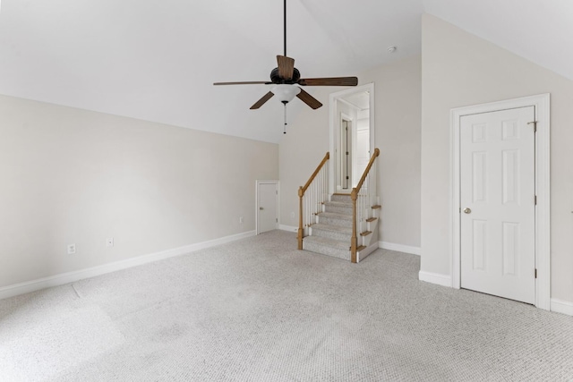 unfurnished living room with stairway, carpet, baseboards, ceiling fan, and vaulted ceiling