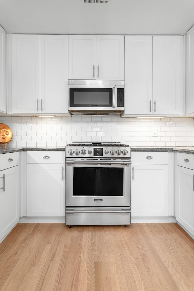 1604 Macoma Dr, Mount Pleasant, SC 29466 - kitchen with stainless steel appliances, white cabinets, and tasteful backsplash