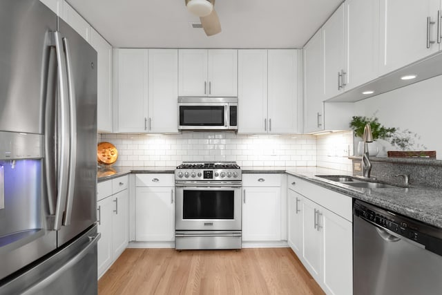 1604 Macoma Dr, Mount Pleasant, SC 29466 - kitchen featuring stainless steel appliances, a sink, light wood finished floors, and white cabinetry