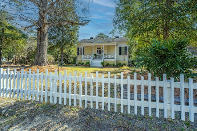 view of front of home with a porch, a front yard, and a fenced front yard