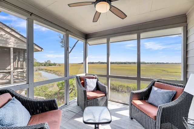 sunroom featuring a water view, a rural view, plenty of natural light, and ceiling fan