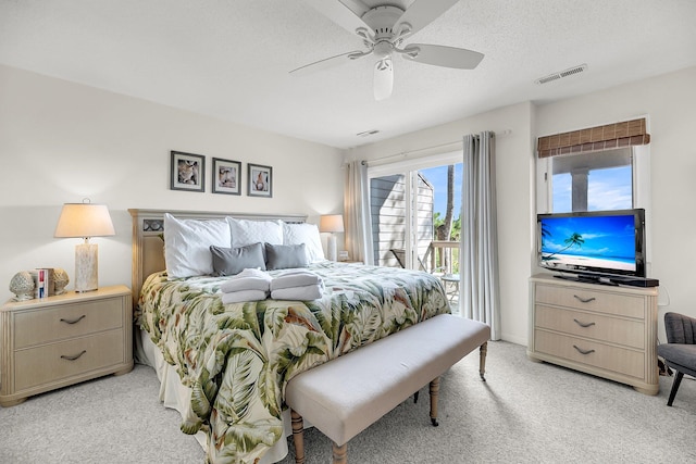 carpeted bedroom featuring access to outside, a textured ceiling, and ceiling fan