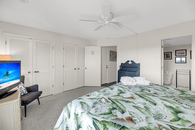 carpeted bedroom with multiple closets, ensuite bath, and ceiling fan