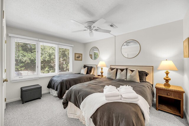 carpeted bedroom with a textured ceiling and ceiling fan