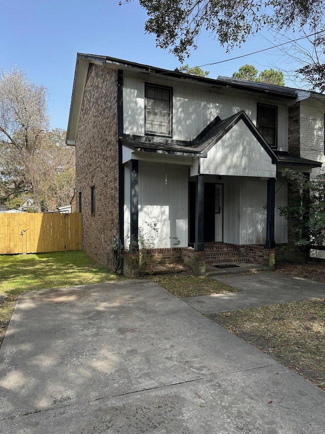 view of front of home with brick siding and fence