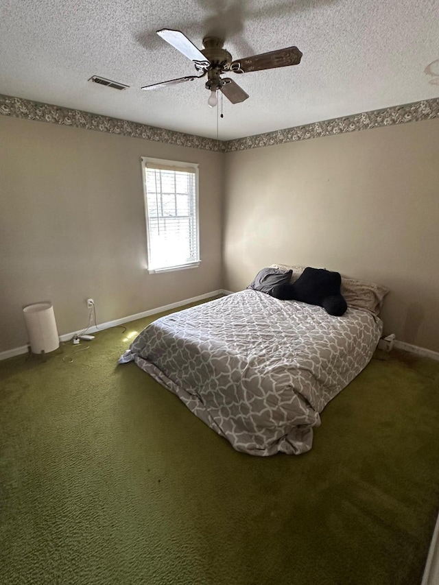 bedroom with visible vents, ceiling fan, baseboards, carpet floors, and a textured ceiling