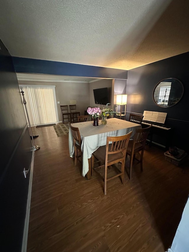 dining room with wood finished floors and a textured ceiling