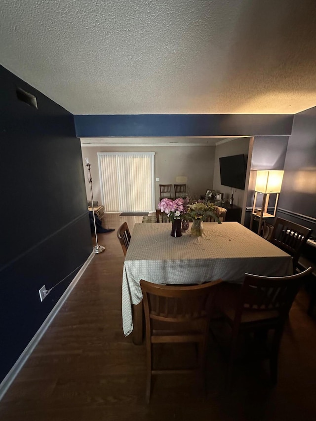 dining area featuring baseboards, a textured ceiling, and dark wood-style floors