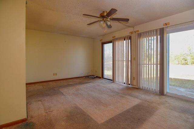 spare room with ceiling fan, light carpet, and a textured ceiling