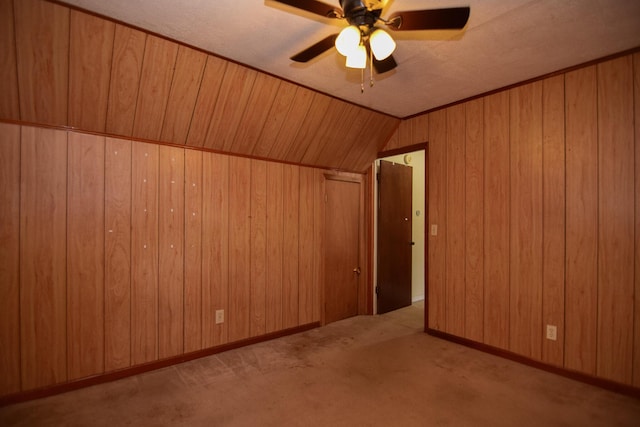 additional living space featuring vaulted ceiling, light carpet, ceiling fan, and wooden walls