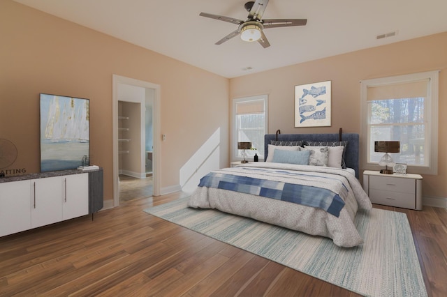 bedroom with hardwood / wood-style flooring, ceiling fan, and multiple windows