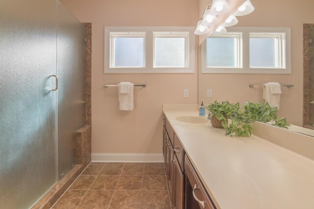 bathroom with tile patterned flooring, vanity, a shower with door, and plenty of natural light