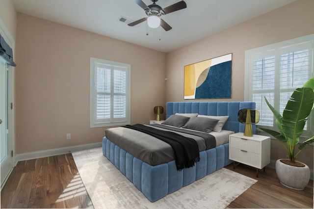 bedroom featuring multiple windows, wood-type flooring, and ceiling fan