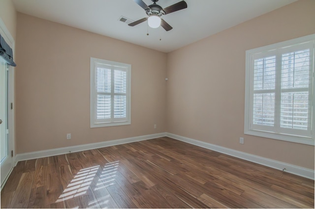 empty room featuring dark hardwood / wood-style flooring, ceiling fan, and a healthy amount of sunlight