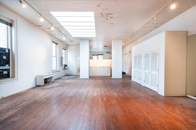 354 King St Unit B, Charleston, SC 29401 - unfurnished living room featuring rail lighting, hardwood / wood-style flooring, and baseboards