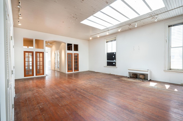 354 King St Unit B, Charleston, SC 29401 - unfurnished living room featuring french doors, track lighting, hardwood / wood-style flooring, and arched walkways