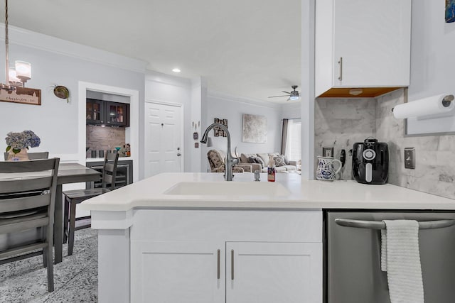 kitchen featuring stainless steel dishwasher, sink, decorative light fixtures, white cabinetry, and decorative backsplash