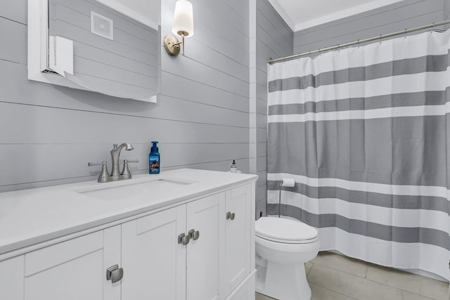 bathroom featuring toilet, vanity, a shower with curtain, and wooden walls