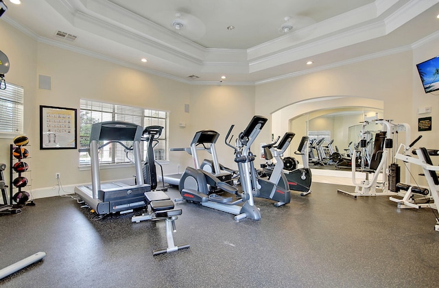 exercise room with a tray ceiling and crown molding