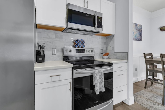 kitchen featuring backsplash, white cabinetry, dark hardwood / wood-style flooring, and stainless steel appliances