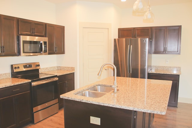 303 Citation Way, Moncks Corner, SC 29461 - kitchen with stainless steel appliances, light wood finished floors, a center island with sink, and light stone counters