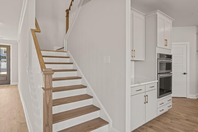 stairs featuring wood finished floors and baseboards