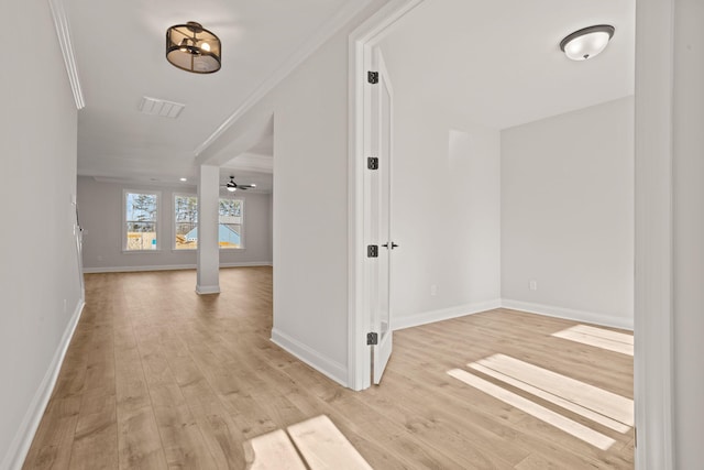 foyer featuring ornamental molding, light wood-type flooring, and baseboards