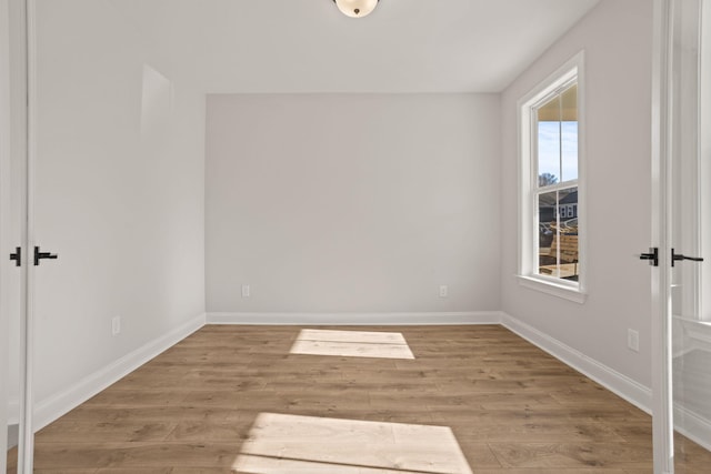 spare room featuring wood finished floors and baseboards