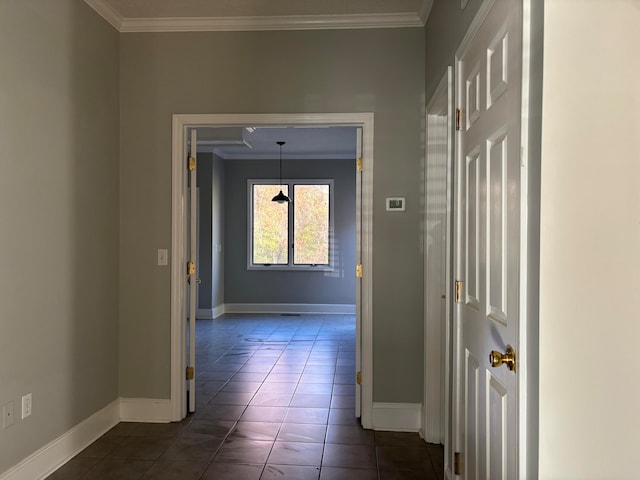 corridor with dark tile patterned floors and crown molding