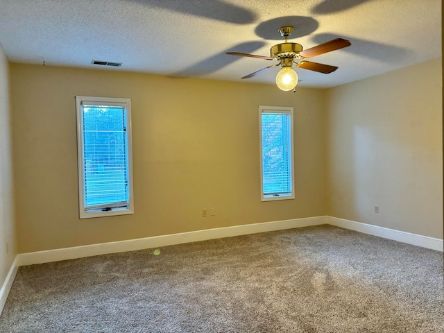 empty room with ceiling fan, carpet, and a textured ceiling