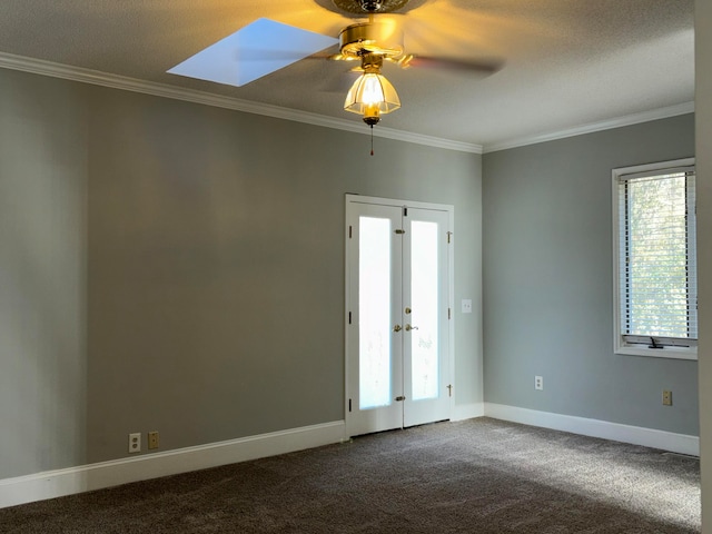 spare room featuring carpet, ceiling fan, crown molding, and a skylight