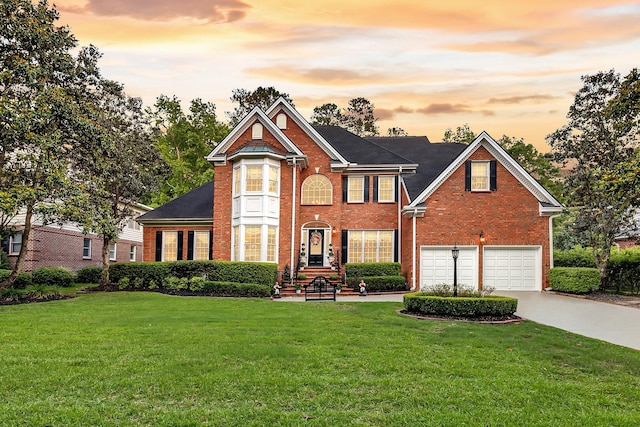 8662 W Fairway Woods Dr, North Charleston, SC 29420 - view of front facade with brick siding, concrete driveway, a lawn, and an attached garage