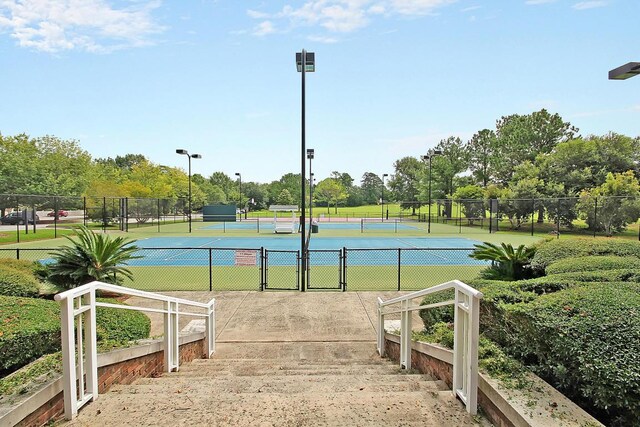 8662 W Fairway Woods Dr, North Charleston, SC 29420 - view of tennis court featuring a gate, fence, and view of scattered trees