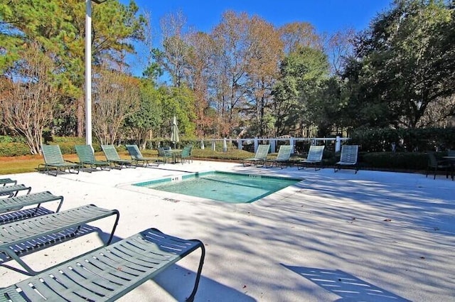 8662 W Fairway Woods Dr, North Charleston, SC 29420 - community pool with a patio area and view of wooded area