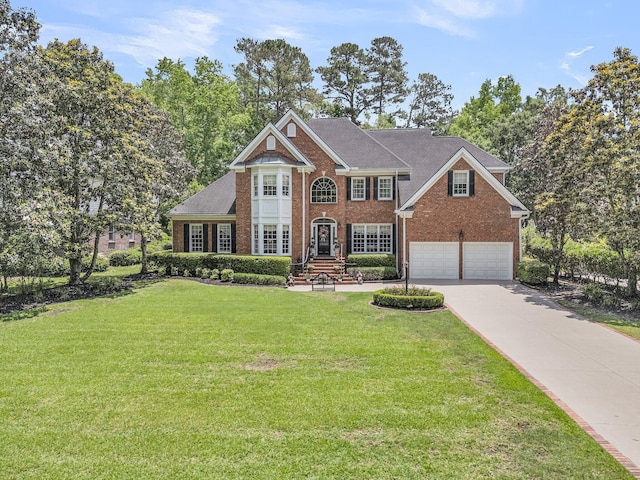 8662 W Fairway Woods Dr, North Charleston, SC 29420 - colonial home featuring brick siding, driveway, an attached garage, and a front lawn
