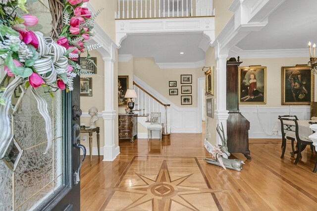 8662 W Fairway Woods Dr, North Charleston, SC 29420 - entrance foyer featuring decorative columns, crown molding, a decorative wall, stairway, and a wainscoted wall