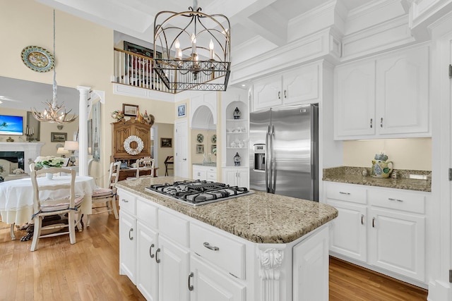 8662 W Fairway Woods Dr, North Charleston, SC 29420 - kitchen with stainless steel appliances, a chandelier, a center island, light stone counters, and a towering ceiling