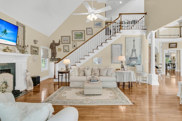 8662 W Fairway Woods Dr, North Charleston, SC 29420 - living room featuring high vaulted ceiling, ceiling fan, stairs, wood finished floors, and a fireplace
