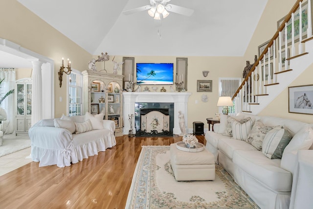 8662 W Fairway Woods Dr, North Charleston, SC 29420 - living area with ceiling fan, a fireplace, wood finished floors, stairway, and high vaulted ceiling