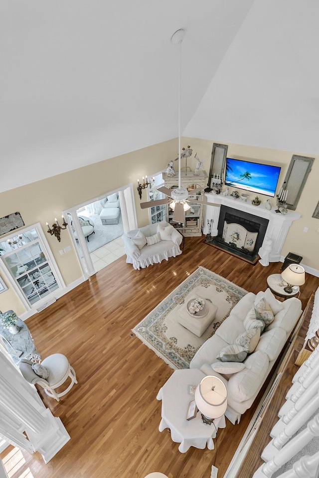 8662 W Fairway Woods Dr, North Charleston, SC 29420 - living area with wood finished floors, a fireplace with raised hearth, vaulted ceiling, and ceiling fan